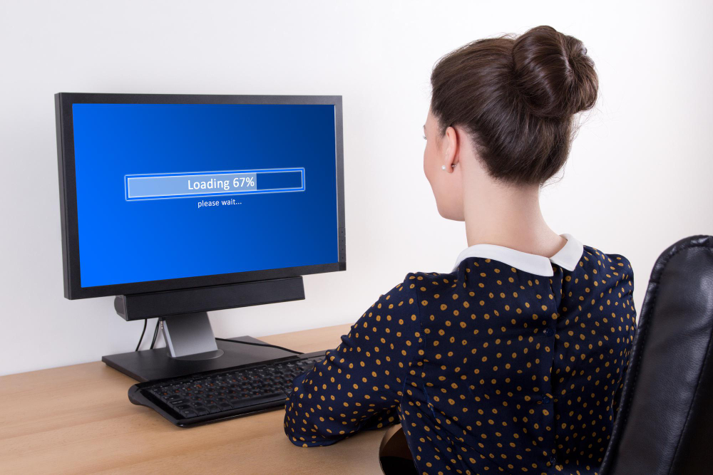 Young Business Woman Downloading Something From Internet in Office