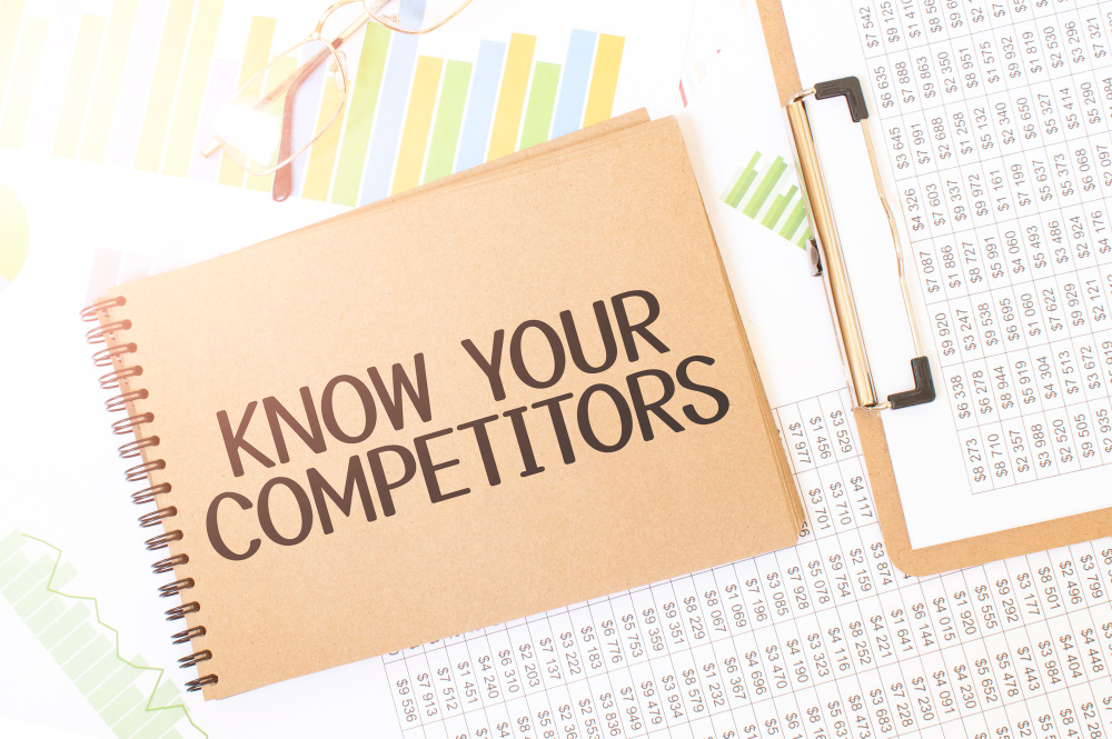 Business up Graph on a Sheet of Craft Colour Notepad With Know Your Competitors Sign