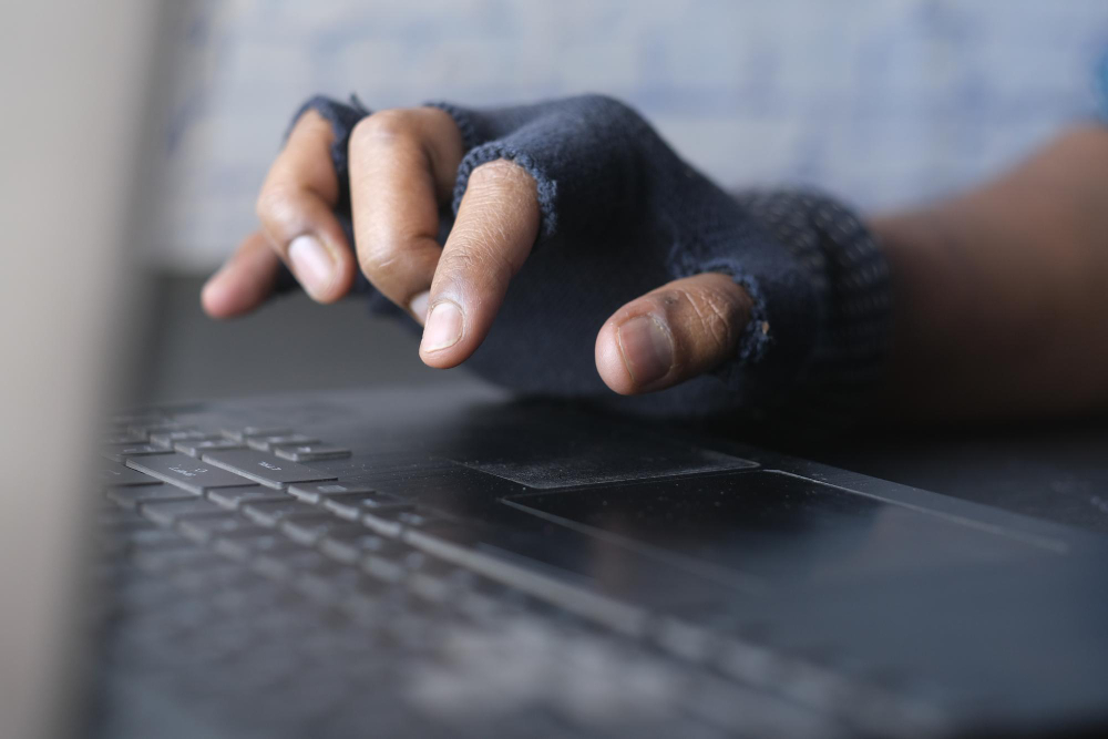 Hacker Hand Stealing Data From Laptop Top Down